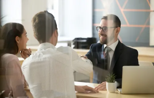 Two clients speaking with an insurance agent 