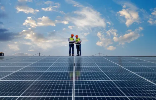 two people standing on solar panel