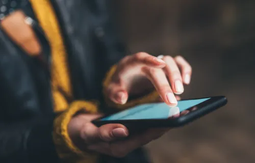 Woman taps mobile phone screen