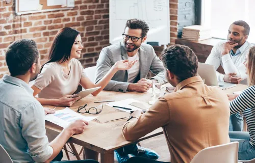 young colleagues sitting around a table discussing business