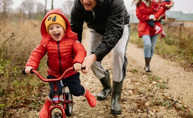 Child riding a bike with adult supervision