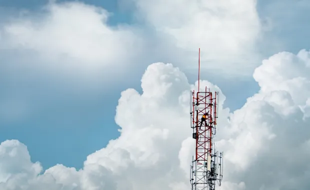 Aerial view of 5G telecommunications tower with clouds in background