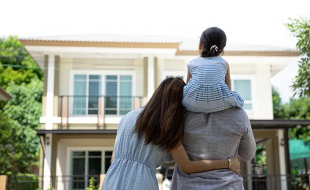 Happy Asian family. Father, mother and daughter near new home. Real estate background with copy space