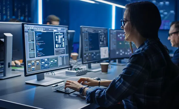 IT programer working on computer in data center system control room