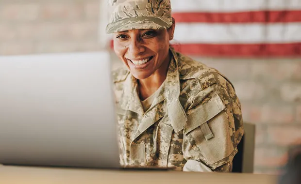 service member sitting in front of a computer 