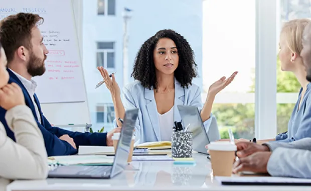 A group of diverse professionals sitting at a table having a meeting 