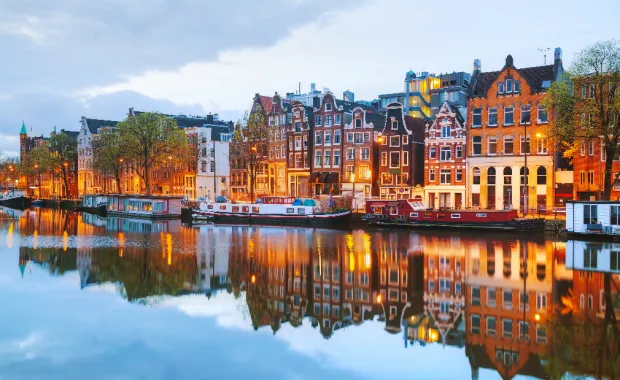 Maisons colorées d’Amsterdam reflétées dans l’eau en soirée