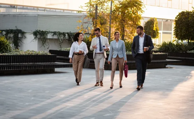 A group of people walking outside an office building