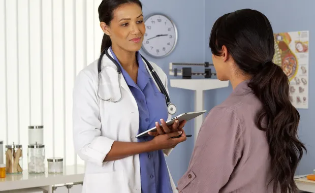 Doctor with clipboard has a consultation with a patient