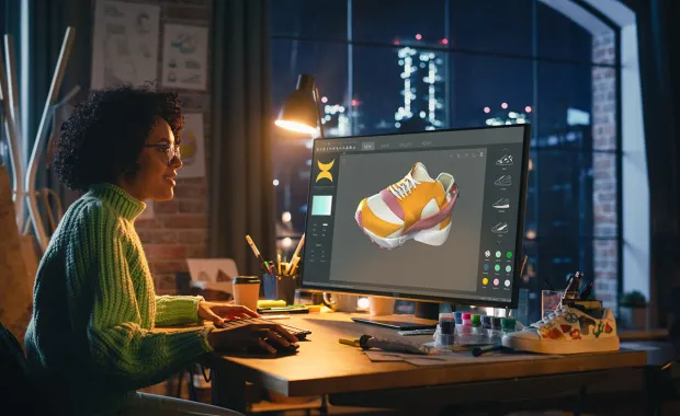 Woman looking at 3D shoe on computer screen