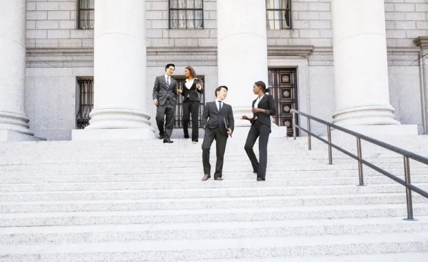 Group of people standing on stairs outside of a government building