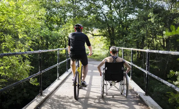 Cyklist och rullstolsbunden tränar tillsammans