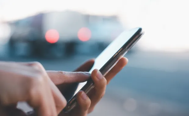 Closeup of hands holding and scrolling through mobile phone