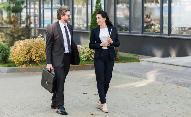 Male and female professional walking into an office 