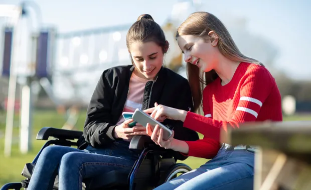 Two teens looking at mobile device