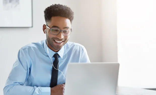 Young professional smiling at laptop