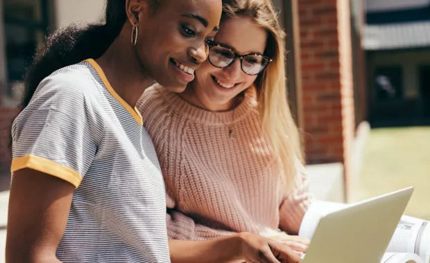 Two female university students looking at a laptop