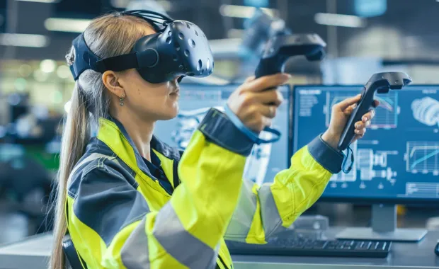 Ingénieur industriel portant un casque de réalité virtuelle et tenant des contrôleurs