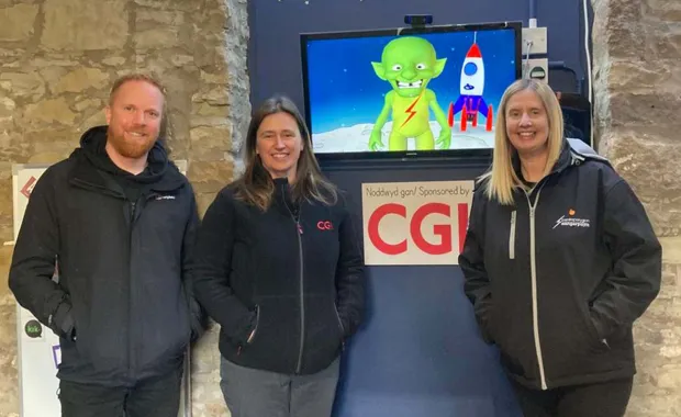 Members of CGI and DangerPoint standing infront of K-os an interactive alien on a TV 
