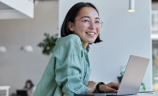 Female professional working on corporate laptop and smiling 