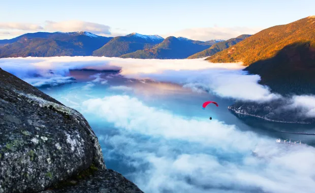 person hang gliding in mountains