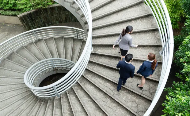 Personne conduisant deux personnes dans un escalier en colimaçon