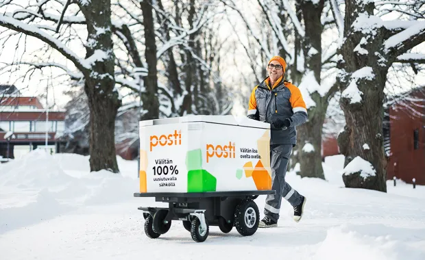 Posti employee moving a parcel on a dolly