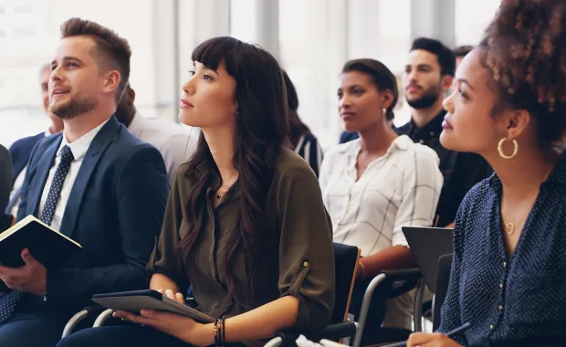 Professionals listening to a speaker at a event