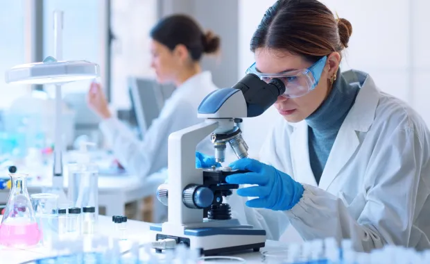 researcher using microscope in lab
