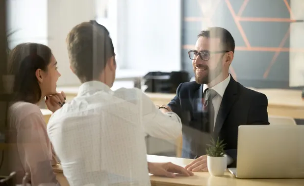 Two clients speaking with an insurance agent 