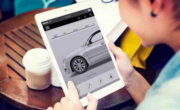 Woman looks at car on tablet device