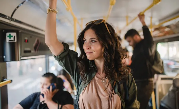  A confident woman riding public transport, her face lit up with a joyful smile