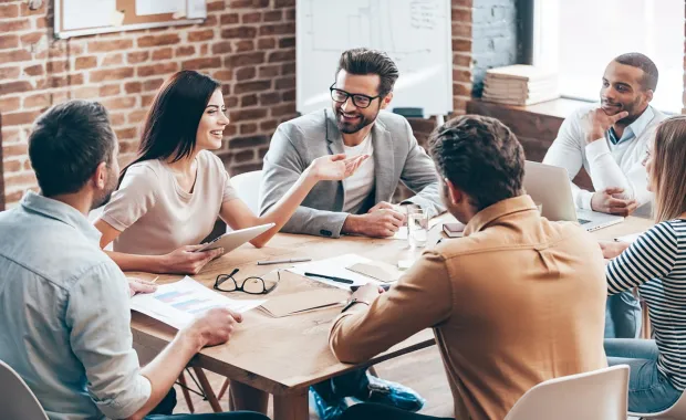 young colleagues sitting around a table discussing business