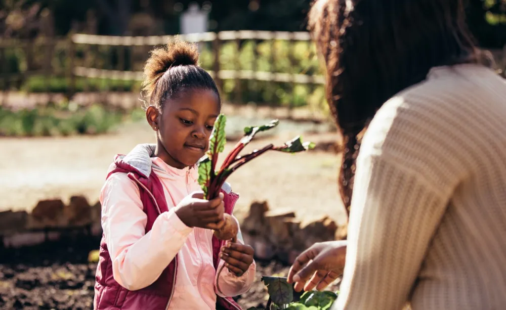 Little girl helping her mother in the garden Little girl helping her mother in the garden