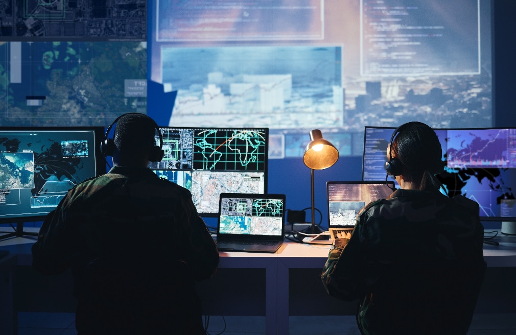 Two professionals analyzing data in front of computer screens