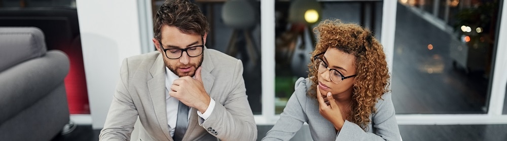 Two colleagues sitting and reviewing documents at a conference table