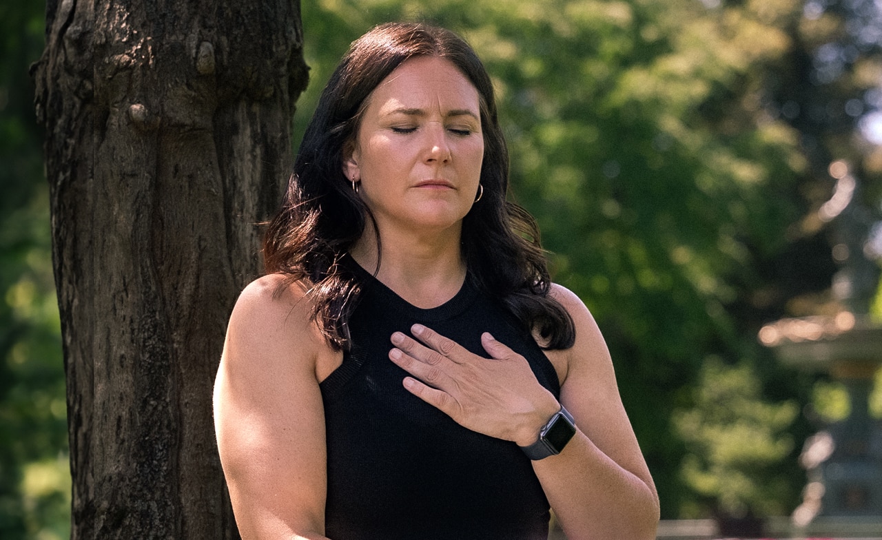 Frau macht Entspannungsübungen im Park