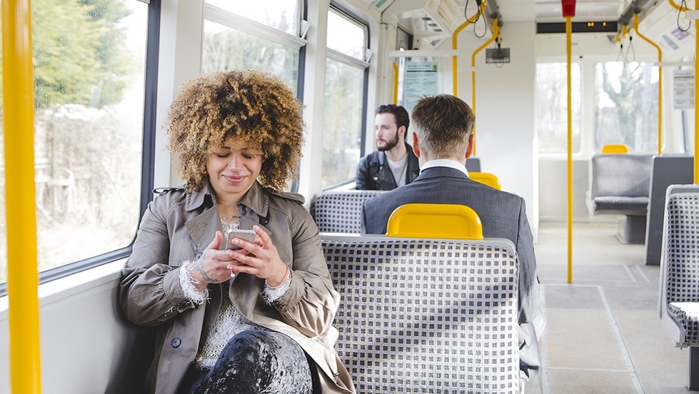 Woman sat on West Midlands Tram looking at her phone Woman sat on West Midlands Tram looking at her phone