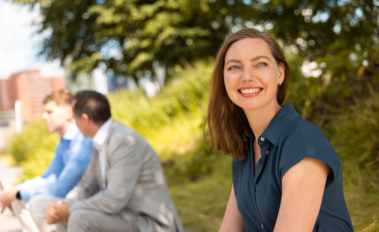 Woman smiling while sitting on a lawn Woman smiling while sitting on a lawn