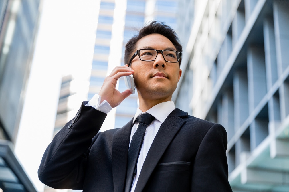 agent-watchful-phone Well-dressed man in city on mobile phone